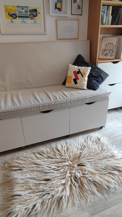Deep-pile flokati rug in ivory white, naturally speckled with beige and brown wool accents, soft cozy texture