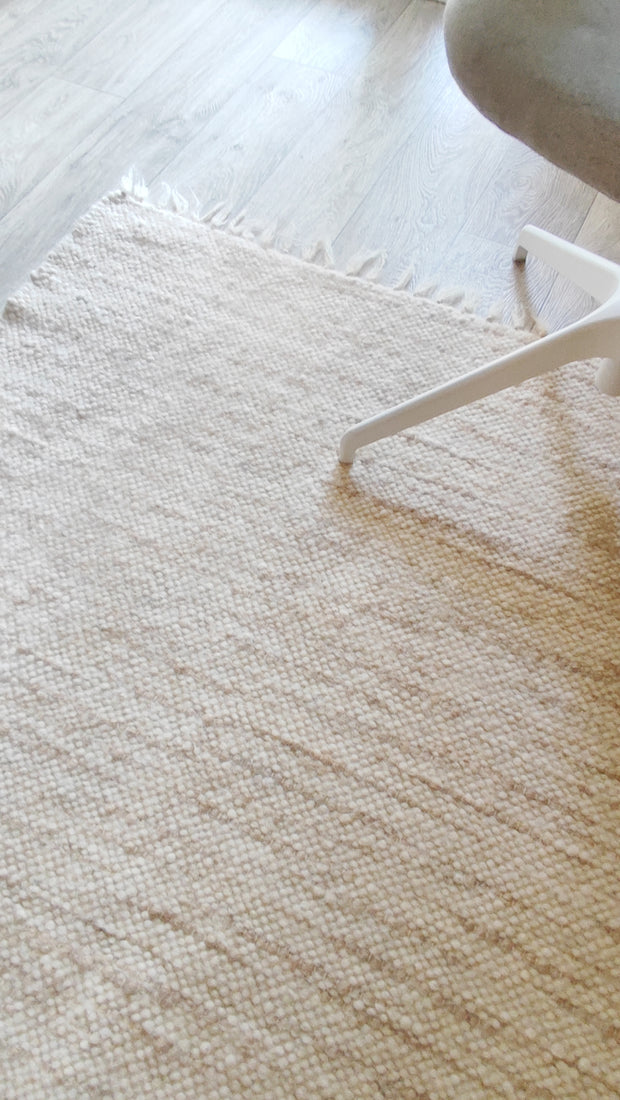 Beshka rug — modern minimalist wool rug, warm beige with cream ivory stripes, sustainable handmade craftsmanship