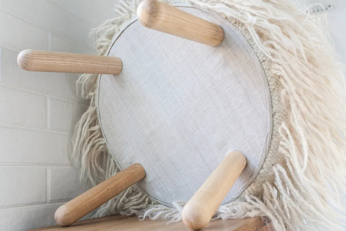 Close-up view of Mapico ottoman's natural wool texture and traditional stitching