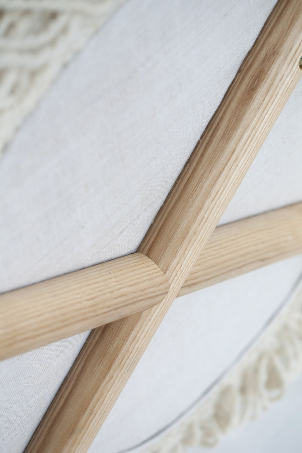 Detail view of Mapico chair’s wooden legs and fabric texture