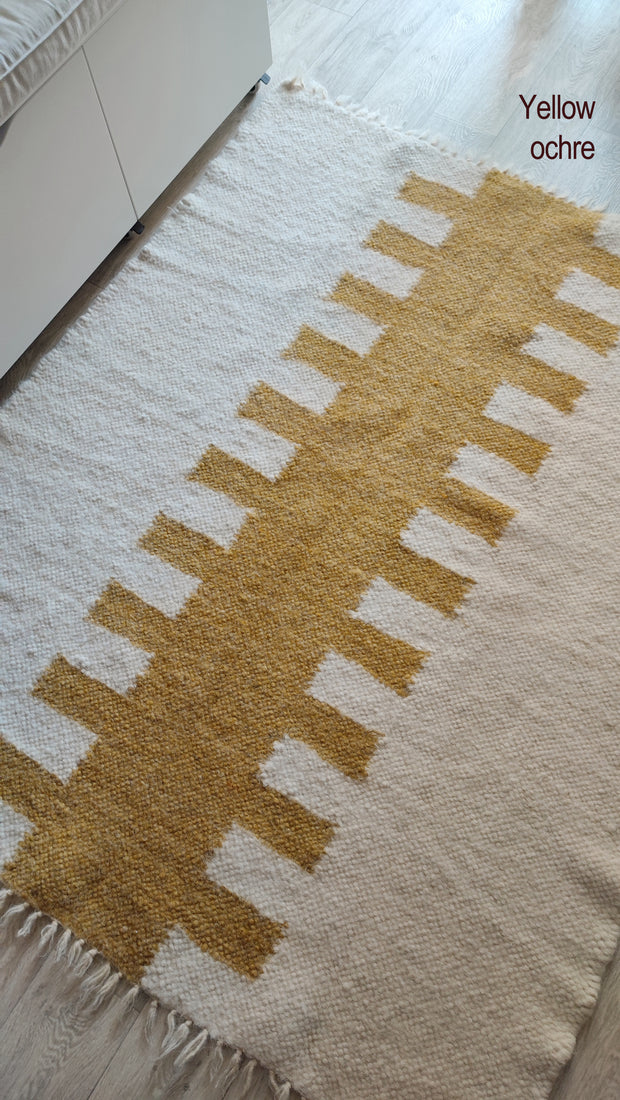 Hand-knotted wool rug, tribal-pattern design in ivory and white tones, traditional craftsmanship meets modern minimalism
