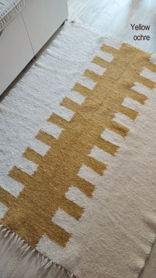 Hand-knotted wool rug, tribal-pattern design in ivory and white tones, traditional craftsmanship meets modern minimalism