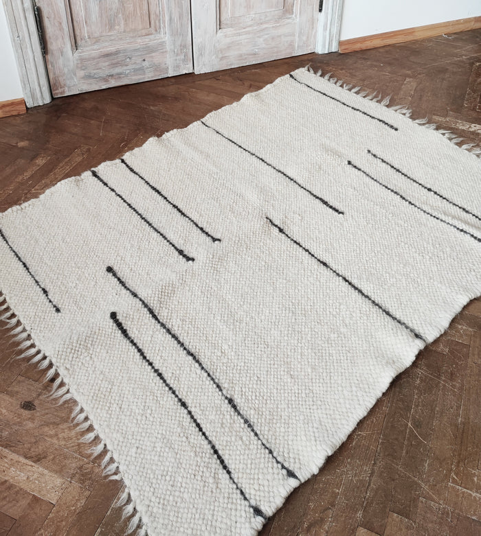 Handwoven wool rug with crisp ivory and dark gray stripes, sculptural texture and understated elegance
