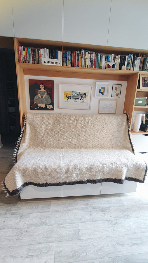 Hand-knotted undyed wool blanket, ivory white center with black framed edge, refined natural home decor