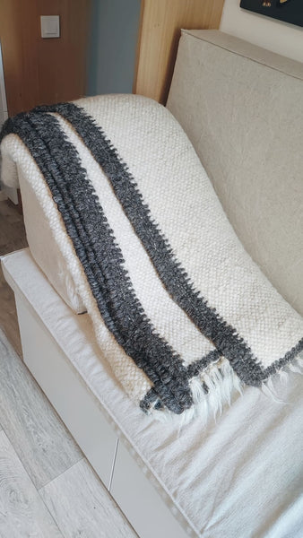 Handmade wool rug in ivory white with black border trim, minimalist Scandinavian-style design