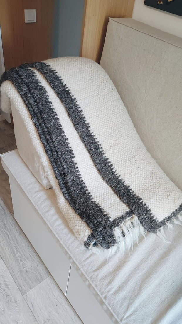 Natural sheep wool area rug, ivory white with a black perimeter stripe, handwoven using traditional techniques