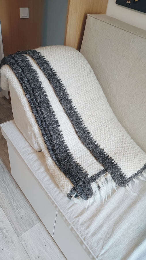 Natural sheep wool area rug, ivory white with a black perimeter stripe, handwoven using traditional techniques