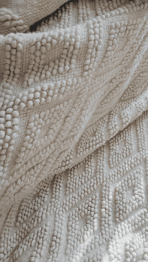 Melanka rug — minimalist all-white wool rug with intricate textured diamond geometry, handmade using centuries-old Ukrainian weaving methods