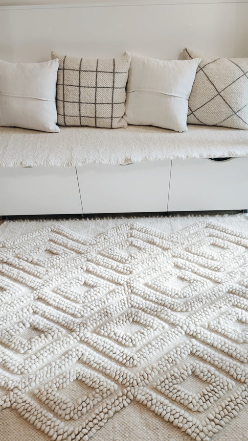 Mena rug — minimalist all-white wool rug with intricate textured diamond geometry, handmade using centuries-old Ukrainian weaving methods