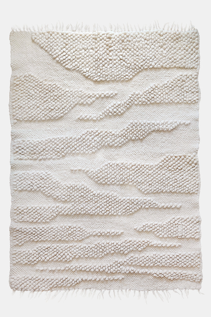 Natural undyed wool rug, ivory-on-ivory abstract design with organic ridge texture inspired by mountain ranges