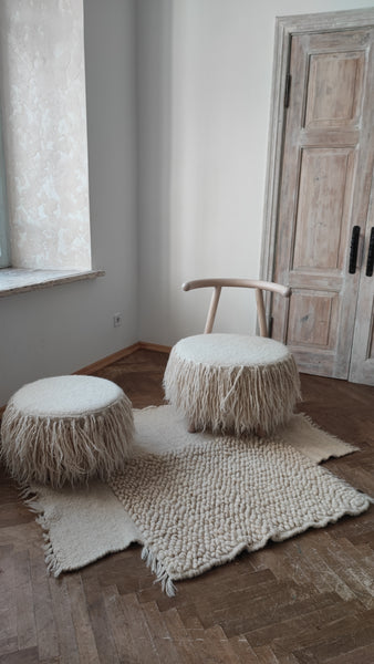 A beige and brown wool rug with a textured design, handcrafted from natural sheep's wool, displayed against a white background.