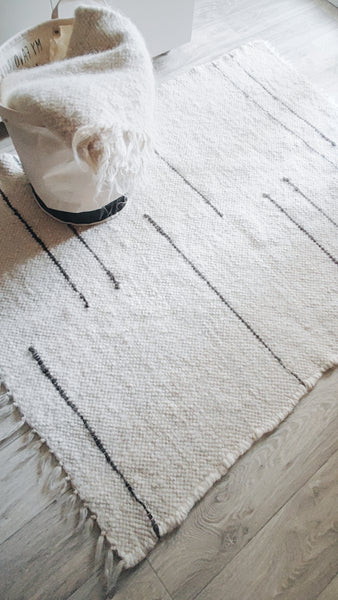 Strypa rug — handmade ivory white wool rug with bold black stripes, minimalist modern design