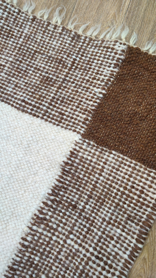 Natural undyed wool rug featuring layered brown geometric squares on an ivory white base, smooth flat-weave craftsmanship