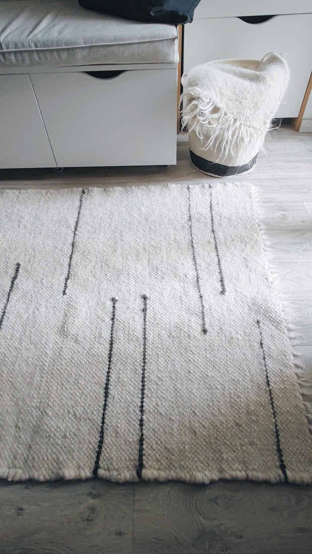 Striped wool area rug in ivory white and dark gray tones, artisan-made from natural sheep wool
