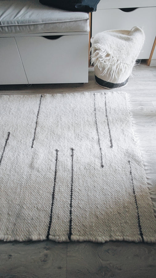 Striped wool area rug in ivory white and dark gray tones, artisan-made from natural sheep wool