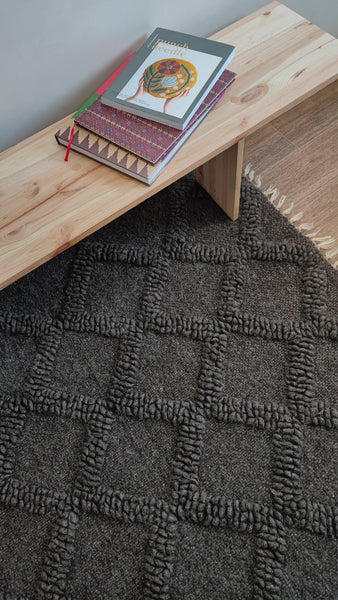 Ternyk rug — dark gray wool rug with sculptural small diamond motif in matching bobble-weave texture, artisan craftsmanship