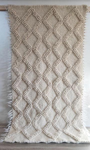 Handwoven wool rug with raised diamond texture in self-tone ivory white, a refined minimalist design from natural sheep wool
