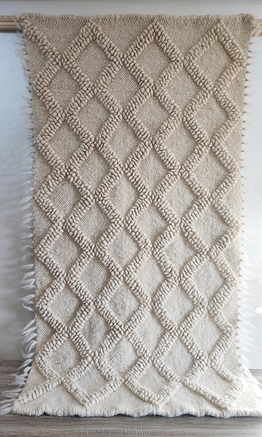 Contemporary minimalist wool rug with subtle diamond relief texture in matching wool tone, natural undyed sheep wool craftsmanship
