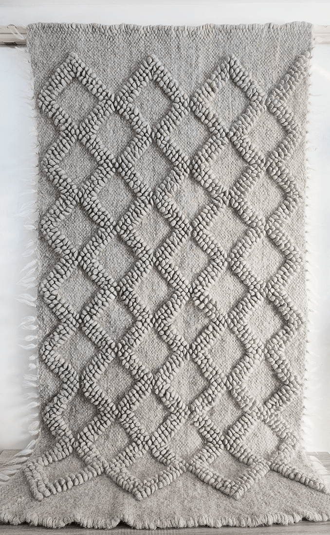 Handwoven wool rug with raised diamond texture in self-tone grey white, a refined minimalist design from natural sheep wool