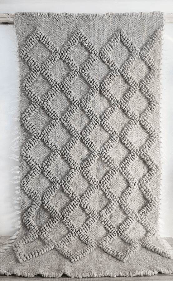 Handwoven wool rug with raised diamond texture in self-tone grey white, a refined minimalist design from natural sheep wool