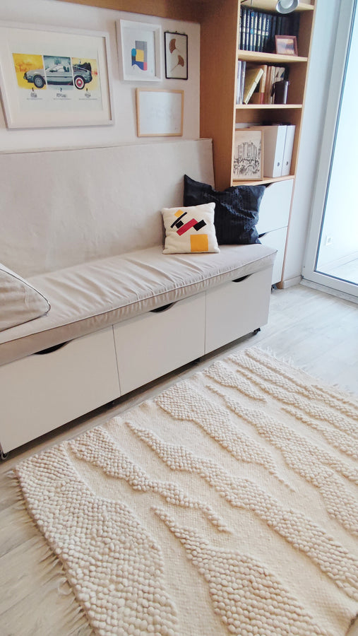 Milova rug – minimalist wool rug with tactile relief texture, ivory white tones echoing a meandering riverbed