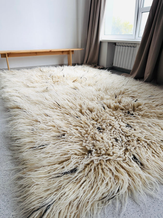 Fluffy ivory white wool rug with organic beige and brown strand accents, handwoven from natural sheep wool