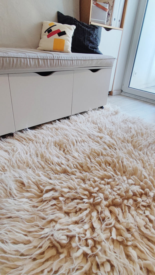 Hand-tufted flokati wool rug, ivory white with soft cascading pile, an artisan-made cozy statement piece
