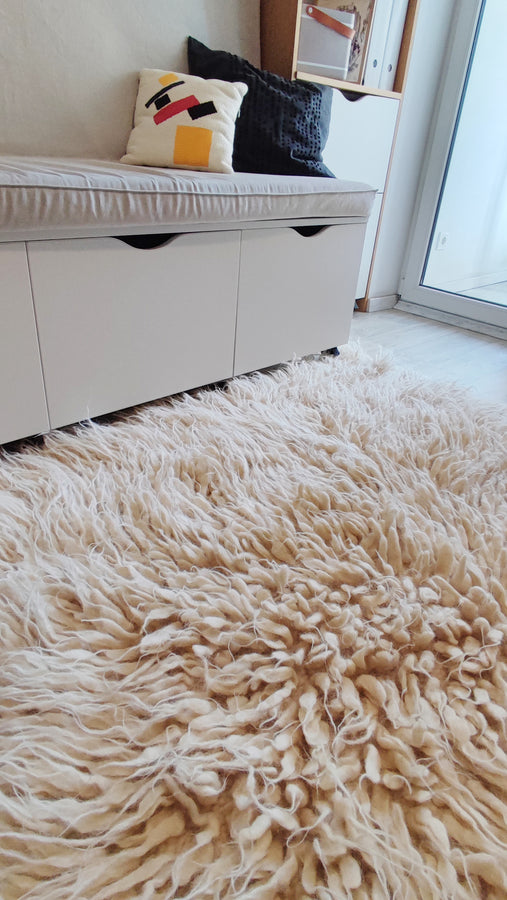 Hand-tufted flokati wool rug, ivory white with soft cascading pile, an artisan-made cozy statement piece