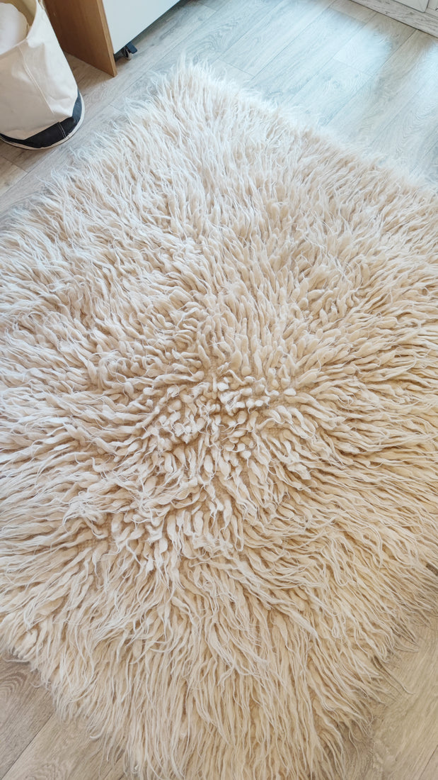 Hand-knotted flokati wool rug, soft deep-pile texture in ivory white, natural undyed sheep wool craftsmanship