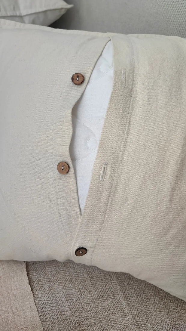Detail of Mapico pillow's natural wooden button closure and linen-cotton fabric texture