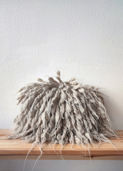 Light grey flokati wool pillow with long textured shags