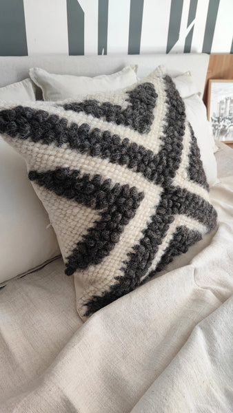 Chaga wool pillow with black and grey bobble pattern on smooth wool base