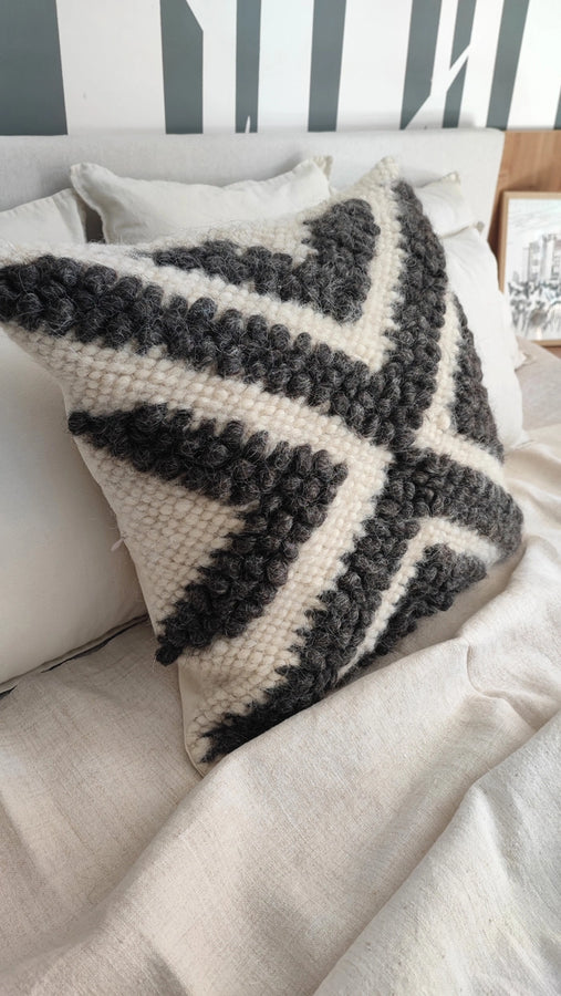 Handmade wool Chaga pillow styled on a bed