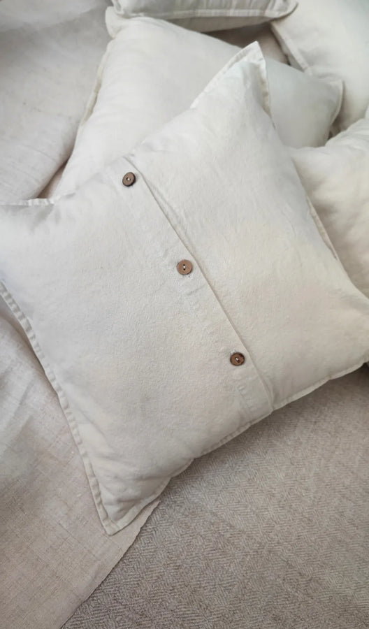 Mapico linen cushion styled on a bed in a minimalist bedroom interior
