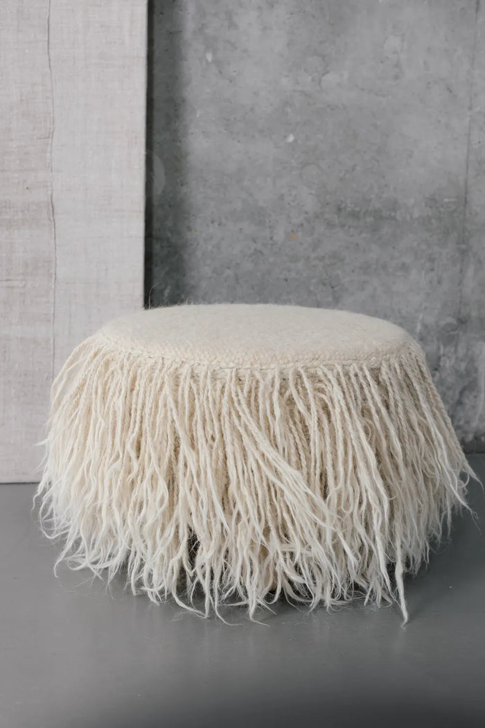 Mapico wool pouf in a modern living room, natural sheep wool ottoman with ash-tree legs