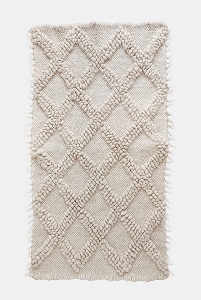 Handwoven wool rug with raised diamond texture in self-tone ivory white, a refined minimalist design from natural sheep wool