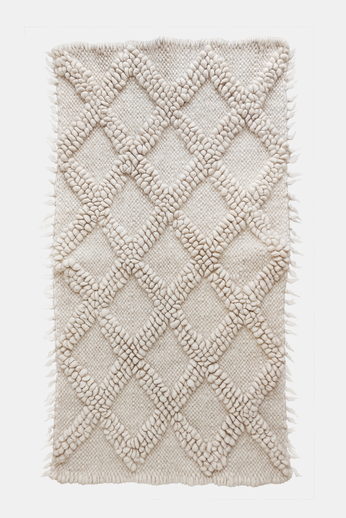 Handwoven wool rug with raised diamond texture in self-tone ivory white, a refined minimalist design from natural sheep wool
