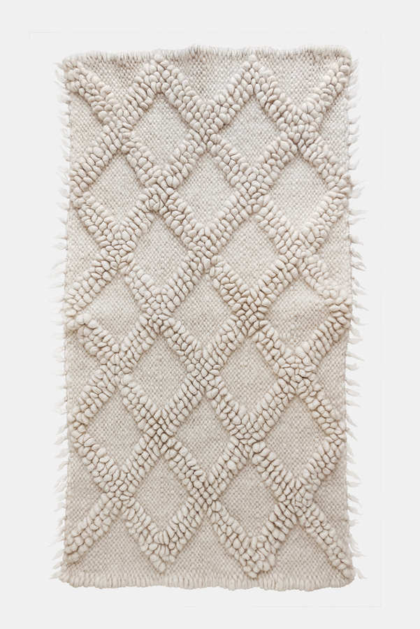 Handwoven wool rug with raised diamond texture in self-tone ivory white, a refined minimalist design from natural sheep wool