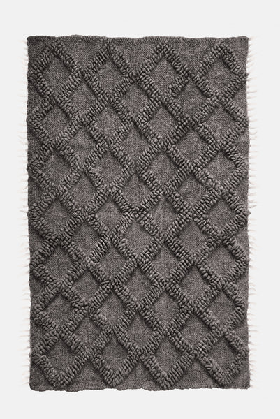Ternyk rug — dark gray wool rug with sculptural small diamond motif in matching bobble-weave texture, artisan craftsmanship