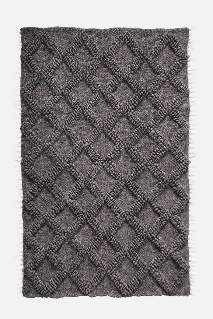 Ternyk rug — dark gray wool rug with sculptural small diamond motif in matching bobble-weave texture, artisan craftsmanship