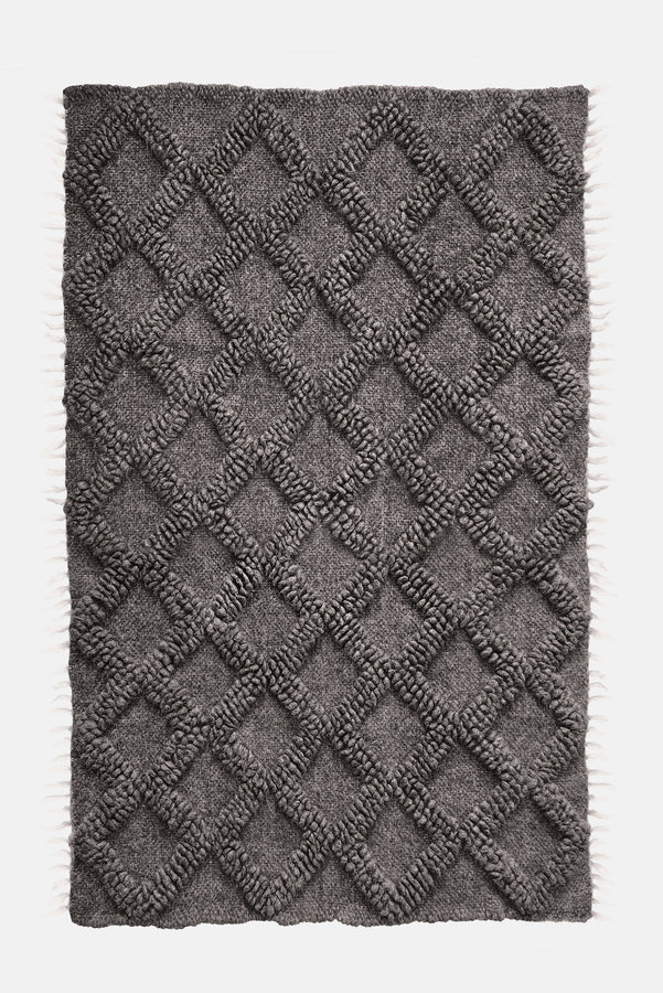 Ternyk rug — dark gray wool rug with sculptural small diamond motif in matching bobble-weave texture, artisan craftsmanship